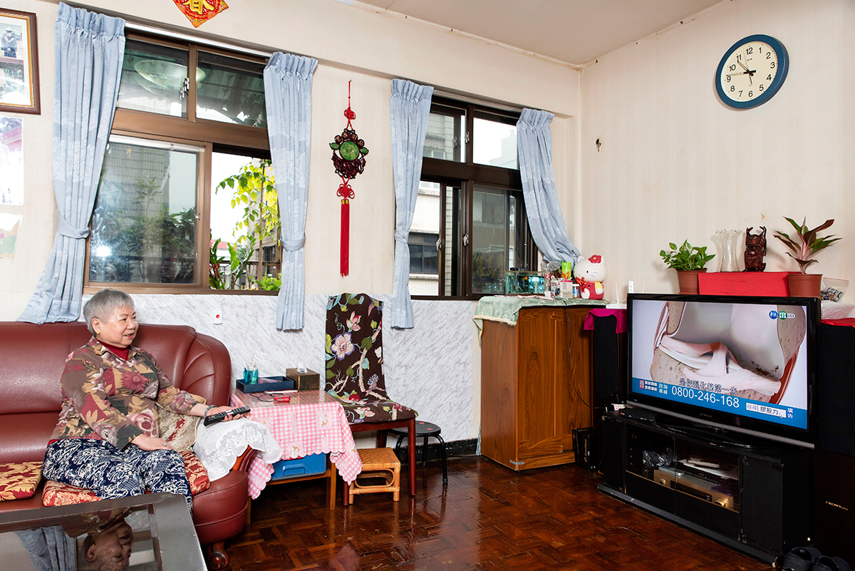 王媽媽住在永和老公寓，平日最常在客廳看電視，沙發旁裝設無線救急器。